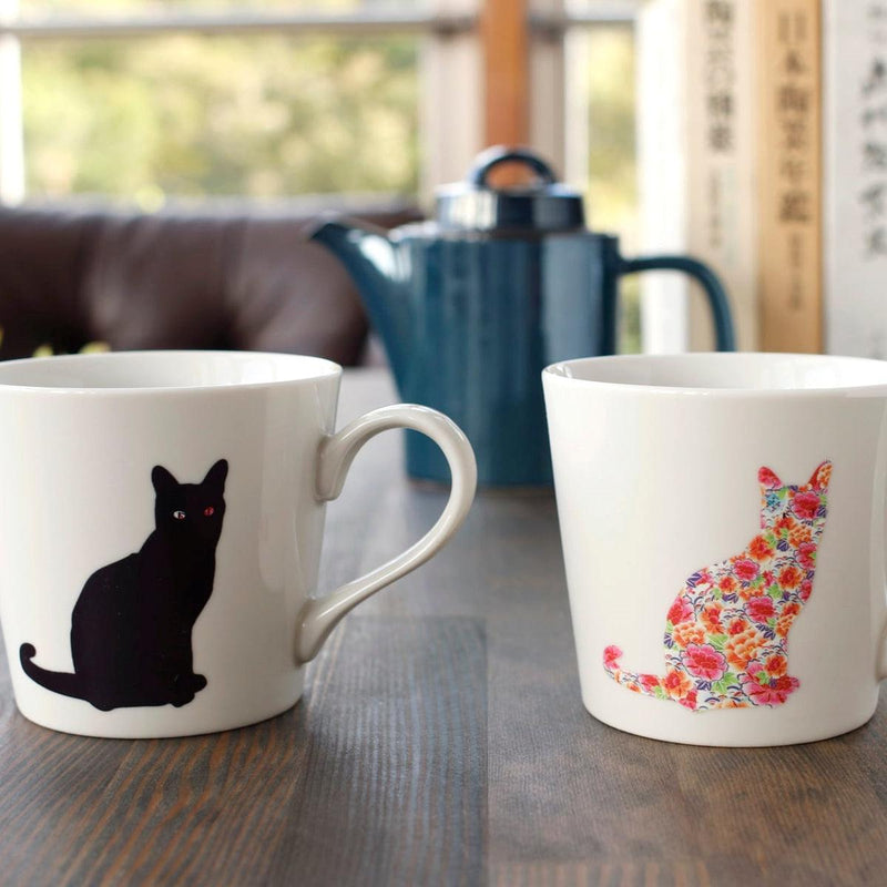 丸モ高木陶器の温感マグカップ 座り猫 白 美濃焼。45℃以上で猫が華やかな花柄に変化